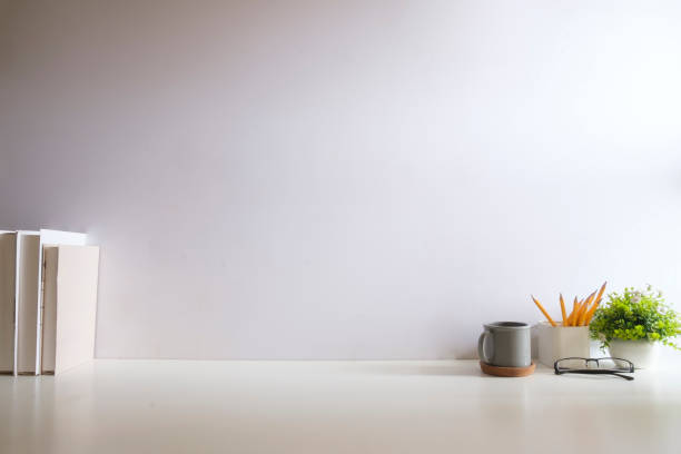 istock Creative designer workplace with picture frame mock up stationery and potted plant on white table. 2073241100