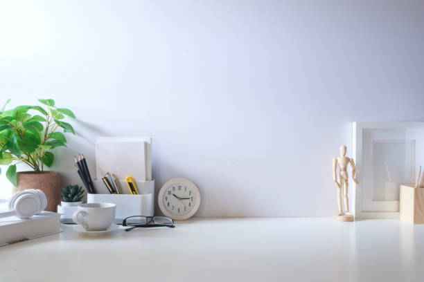 istock Minimal workspace with book, coffee cup and pencil holder on white table. Copy space for your advertising text. 2073241116