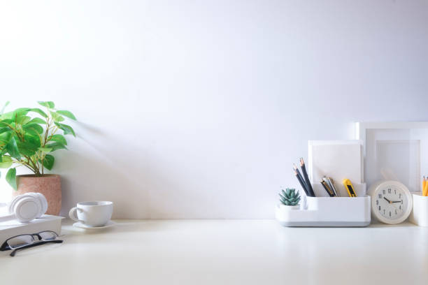 istock Minimal workspace with book, coffee cup and pencil holder on white table. Copy space for your advertising text. 2073241123