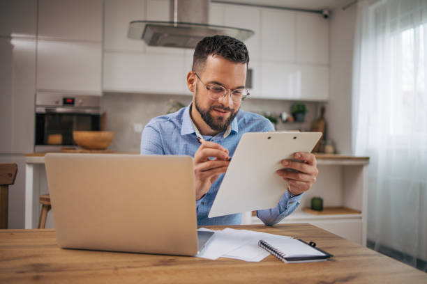 istock Good looking man working at home in his kitchen. 2073243326