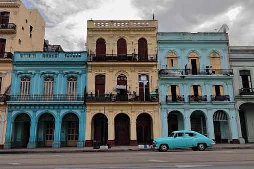 Houses along the Paseo del Prado promenade southernmost end, east side, dating from the early 1900s in eclectic style featuring cast-iron balconies on colorful facades over shady arcades. Havana-Cuba.