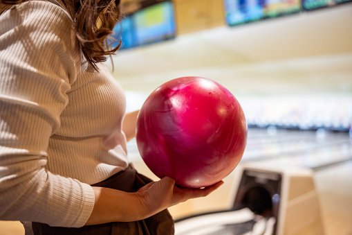 Close-up of woman holding a ball in bowling alley