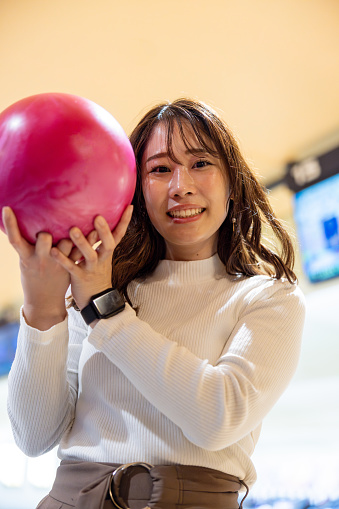 Portrait of woman holding bowing ball - low angle view