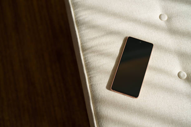 istock A black mobile phone is left on a sofa, with soft sunlight shining on it, high angle view 2073262165