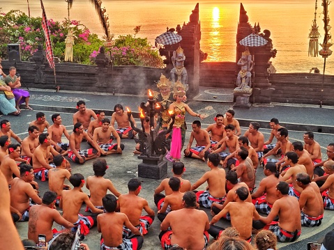 Uluwatu, Bali - September 30, 2023: Group of people performing Kecak dance, Balinese traditional dance in an open air theater