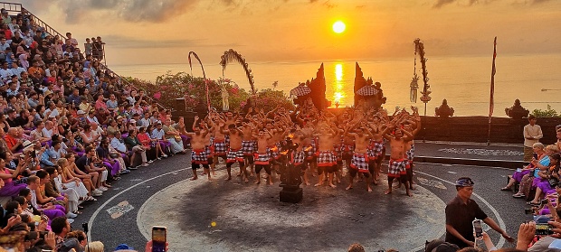 Uluwatu, Bali - September 30, 2023: Group of people performing Kecak dance, Balinese traditional dance in an open air theater