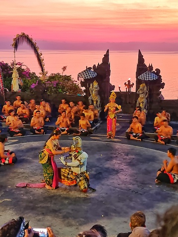 Uluwatu, Bali - September 30, 2023: Group of people performing Kecak dance, Balinese traditional dance in an open air theater