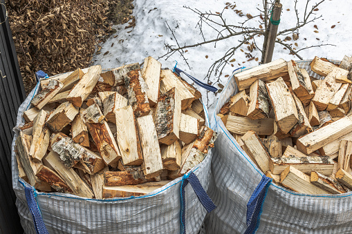 An overhead perspective of transport bags filled with birch firewood on a winter-spring day. Sweden.