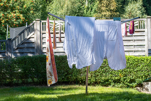 Clothes hanging on rack to dry outdoors in backyard in summer