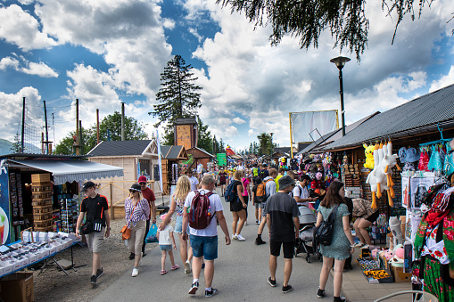 5 july 2023, Zakopane, Poland: Tourists walk along market stand with souvenirs on Gubalowka mountain
