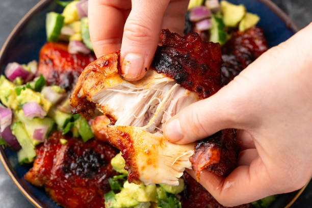 istock Lemon and tomato paste glazed Mediterranean style chicken thighs served with avocado and cucumber salsa, low carb keto meal concept 2073339002