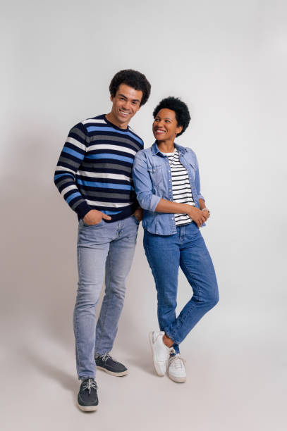 istock Smiling young woman looking romantically at boyfriend while posing together on white background 2073372986