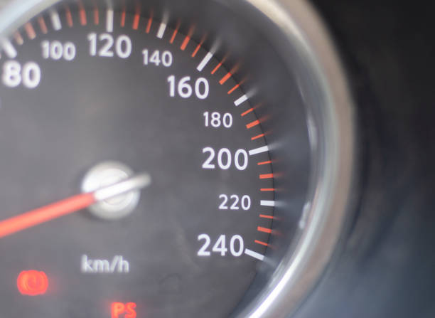 Close up color image depicting a speedometer (or odometer) in a car vehicle interior, with numbers displayed in kilometres per hour. Room for copy space.