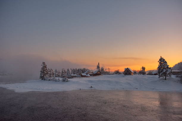 Russia. The South of Western Siberia, the Altai Mountains. A cloudless frosty dawn on the not frozen snow-covered Biya River near the village of Kebezen.