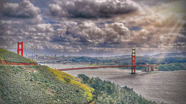 istock Rays of Sunlight Bursting Through Storm Clouds Over Golden Gate Bridge on Rainy Day San Francisco Bay Area Background • Gonzelman Road, Marin Highlands, San Francisco, CA, USA 2073474940