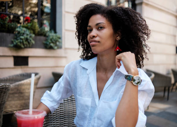 istock Black woman sitting on terrace table drinking juice. 2073481210