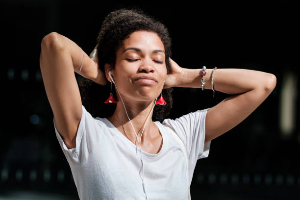 istock Peaceful young curly model enjoying music in the sunlight. 2073481302