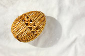 An Easter egg woven from straw lies on the table.