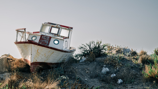 An old abandoned fishing boat on a sand hill.