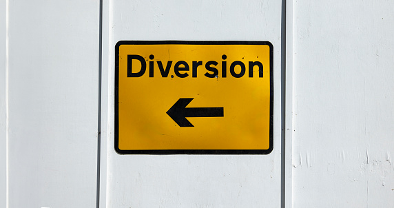 Yellow diversion sign with black left facing arrow, sign for road works