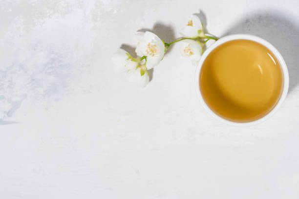 pialat with green tea. white background and jasmine, top view