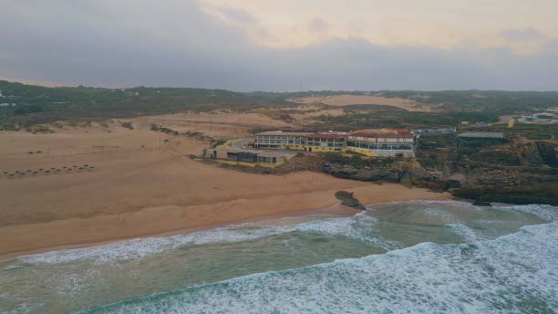 istock Foamy ocean waves rolling to empty sandy beach in super slow motion aerial view 2073571253