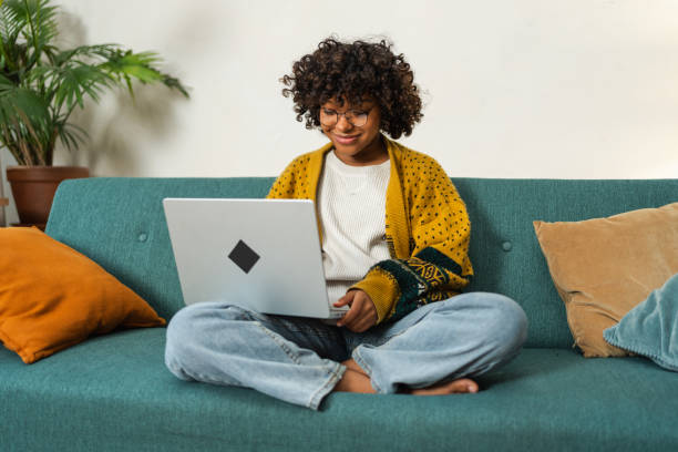istock African American girl using laptop at home office typing chatting reading writing email. Young black woman having virtual meeting online chat video call conference. Work learning from home. 2073598349