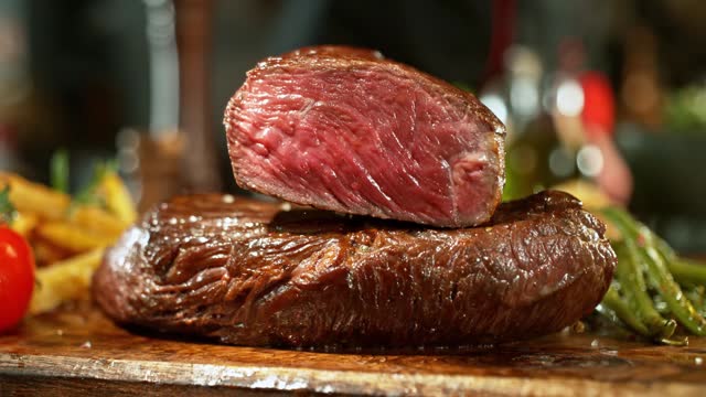 Super Slow Motion of Flying Beef Steak on another Steak.