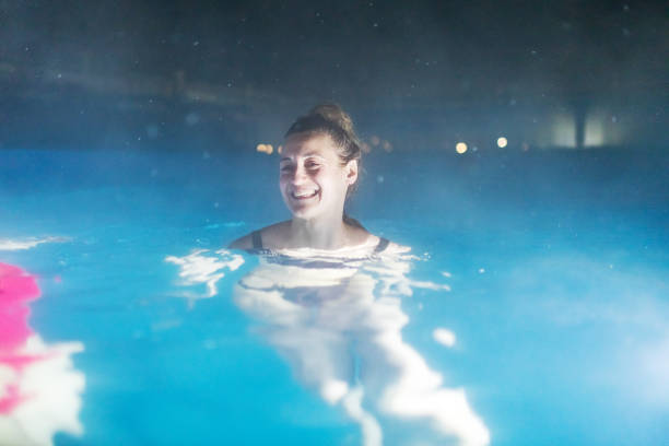 two females resting in pool in luxury spa hotel - apres ski copy space happiness smiling ストックフォトと画像