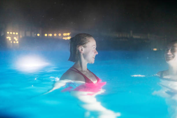 two females resting in pool in luxury spa hotel - apres ski copy space happiness smiling ストックフォトと画像