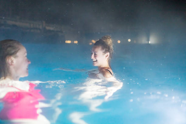 two females resting in pool in luxury spa hotel - apres ski copy space happiness smiling ストックフォトと画像