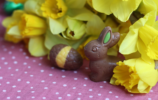 Milk chocolate bunny and eggs on a table. Bright and colorful Easter card.