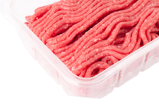 Ground meat in plastic container on white background