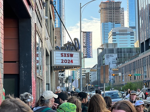 Austin, Texas March 9, 2024 - SXSW 2024 sign on front of historic Antoine's music venue with people waiting to get in. High quality photo