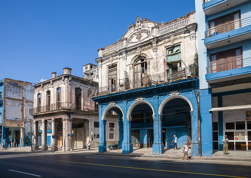 Havana, Cuba - 2012, December 10 : A large street with decaying colonial buildings and local pedestrians in the center of Havana in Cuba