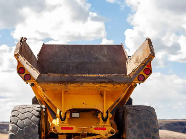 Photo of Cloce up of the back of a yellow John Deere 250C Articulated Dump truck at coulee