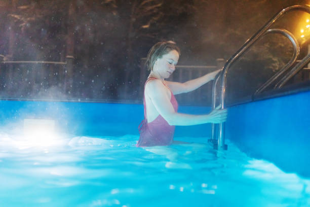 mid adult woman getting out of swimming pool - apres ski lifestyles people blue ストック�フォトと画像