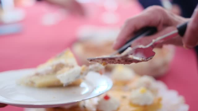Cropped video of people cutting and eating sweet delicious cakes at table