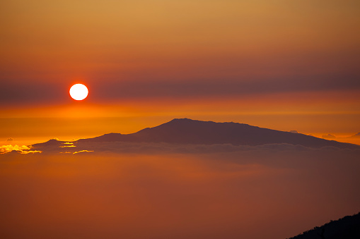 awesome sundowner at mauna kea volcano (big island) view to haleakala volcano (maui island), hawaii islands, usa.