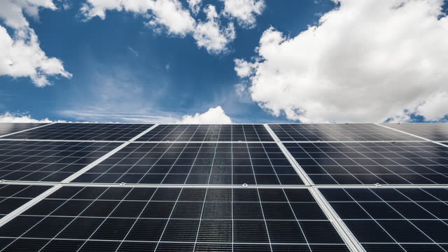 Clouds float quickly over solar power plant panels
