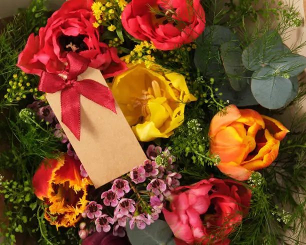 Colorful spring tulips with empty gifttag, present for March 8, International Women's Day, birthday