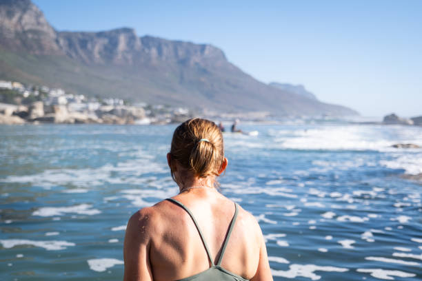 Rear view of a woman taking a swim in a cold tidal pool on the majestic coastline near Cape Town.