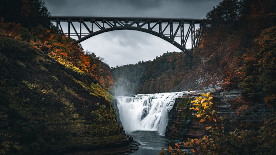 The River flow and fall with vibrant color in a cloudy day during autumn season. Letchworth State Park. United States.