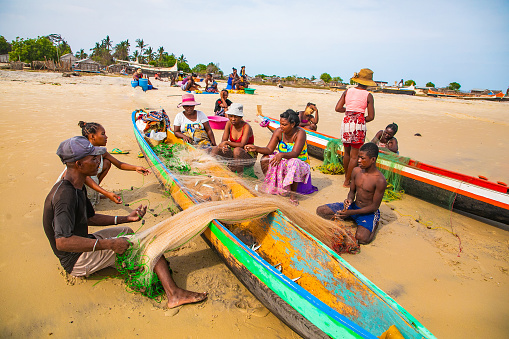 Batavia,western Madagascar, Toliara province.18 october 2023. Inhabitants Madagascar traditional fishing village fold their nets after small catch on ocean shore