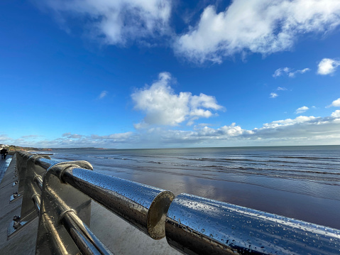 Chrome handrails and bright blue sky on the newly built sea defences at Dawish, Devon, UK