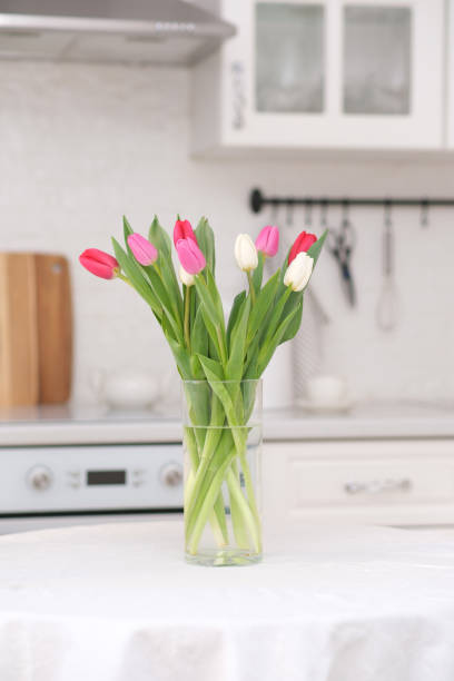 istock Home kitchen interior.Vase with bouquet of pink, white tulips on table at the kitchen. Spring consept. 2073875782