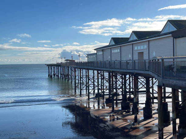 istock Teignmouth pier on bright summer day with blue sky and cumulus clouds 2073878396