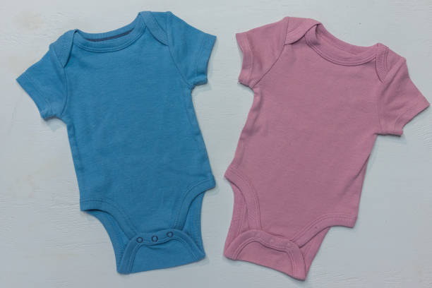 istock One blue onesie and one pink onesie on white background with copy space 2073879936