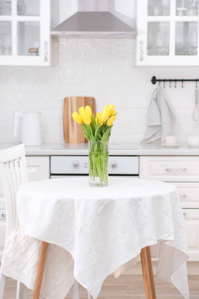 istock Home kitchen interior.Vase with bouquet of yellow tulips on table. Spring consept. 2073881473