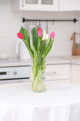 Home kitchen interior.Vase with bouquet of pink white tulips on table. Spring consept. High quality photo